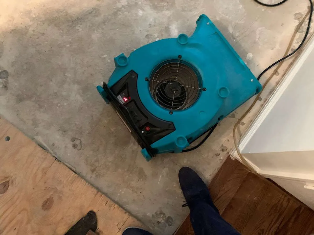 Air mover drying subfloor during Leak Detection & Repair in Aston